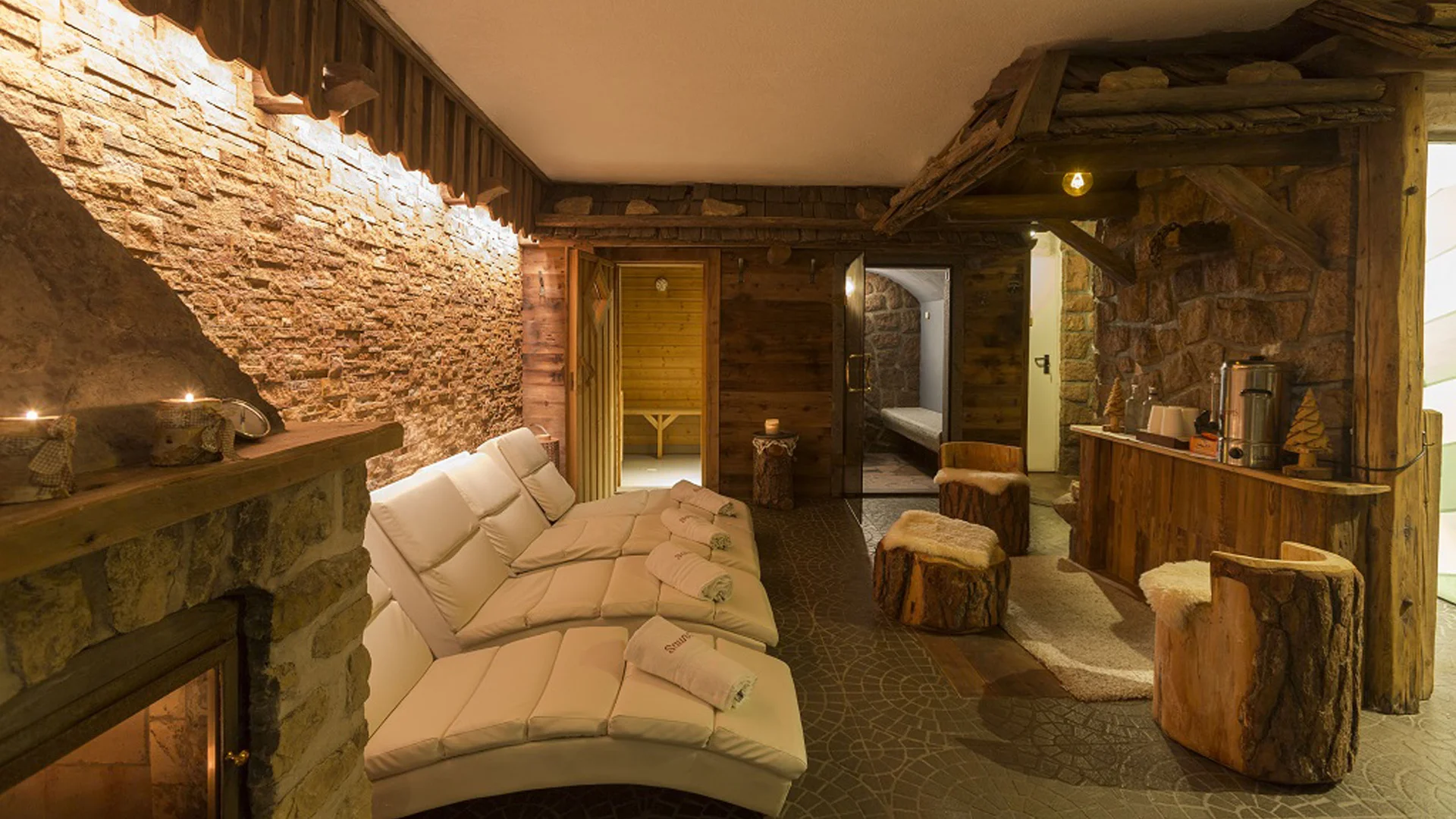 Interno di una spa rustica con divani, camino e arredamento in legno
